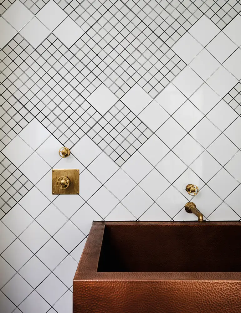White tile arranged with two different sized squares in an asymmetrical pattern.