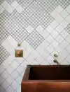 White tile arranged with two different sized squares in an asymmetrical pattern.