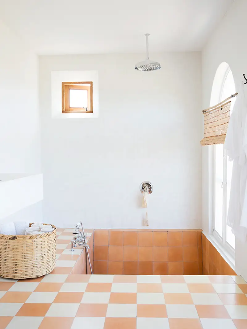 Apricot terracotta and cream checkerboard tiled bathroom with sunken tub.