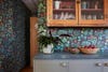 gray-brown bar cabinet with floral wallpaper backsplash
