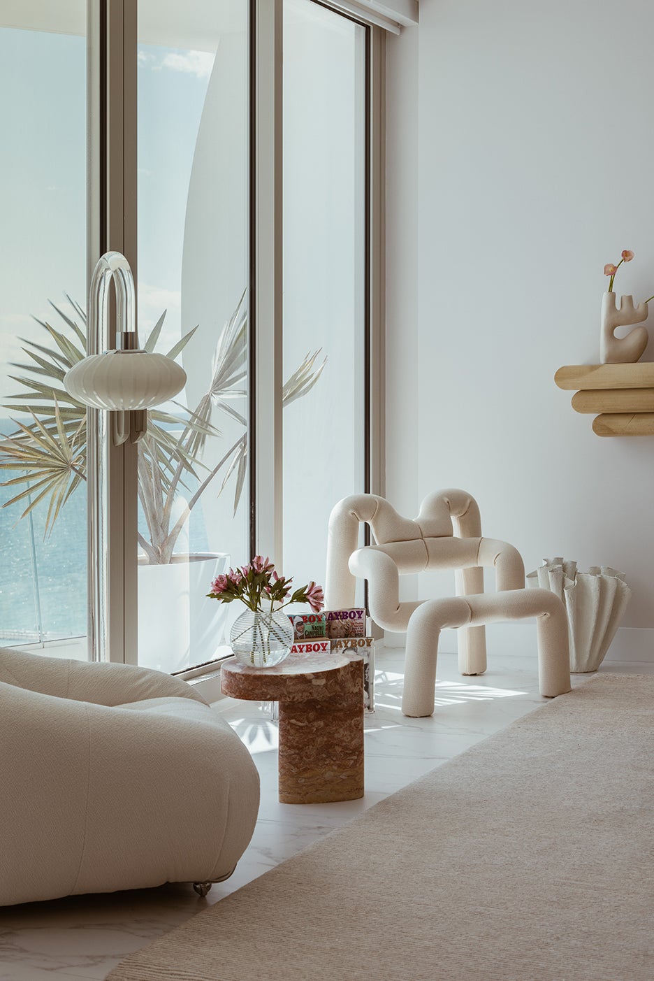 sculptural white furniture in front of sliding doors to balcony