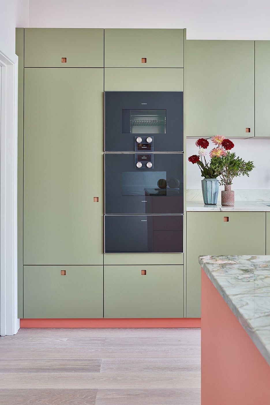 green kitchen cabinets with pink kickplate