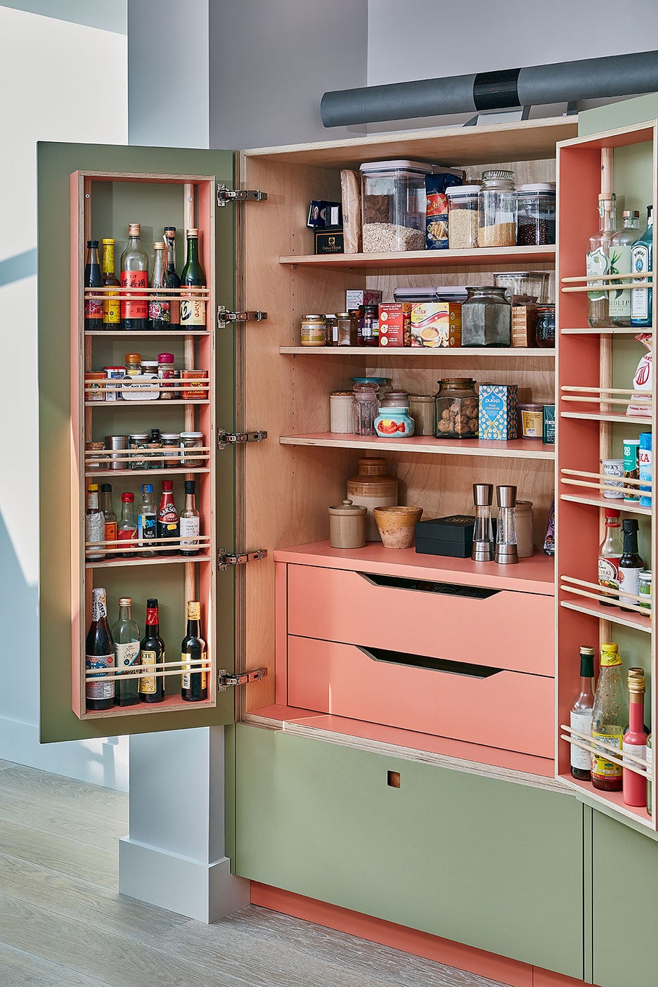 kitchen pantry with door racks and pink drawers