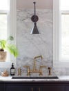 kitchen sink area with marble countertop and backsplash
