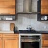 wood kitchen cabinets with tetris-style tile backsplash