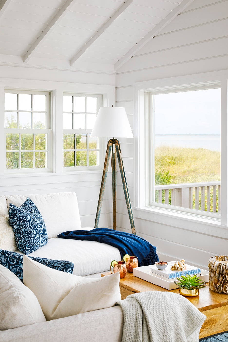 white and blue living room looking out to ocean