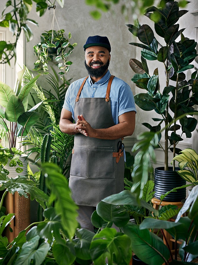 Hilton Carter standing in a room surrounded by plants