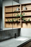 bathroom sink with concrete countertop and wood shelving