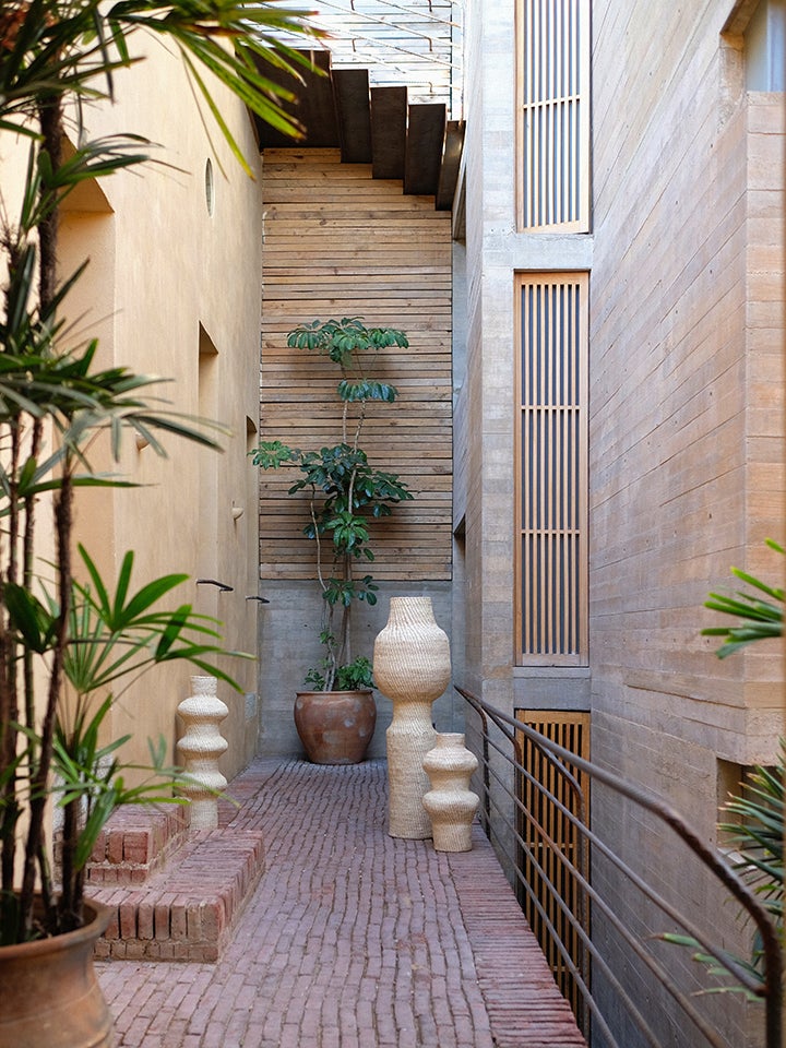 brick courtyard with woven-palm sculptures