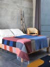 bed with colorful colorblocked blanket
