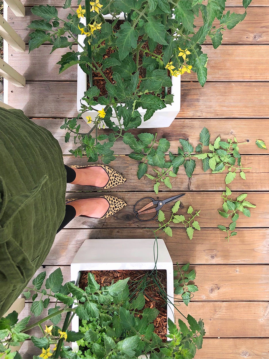woman's feet next to container garden on balcony