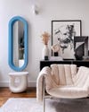oval baby blue mirror and white chair