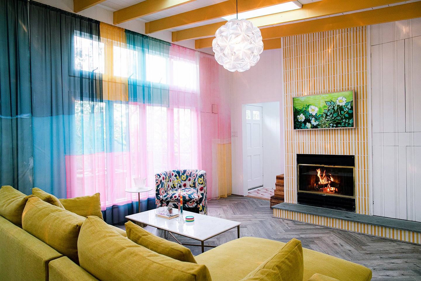 Living room with rainbow curtains and a yellow sofa