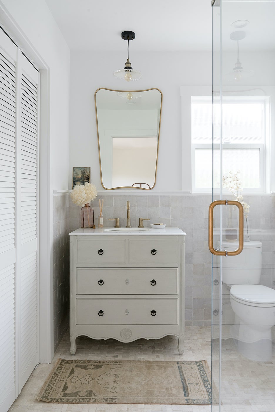 Clean white bathroom with dresser as a vanity