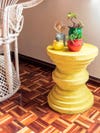 round yellow side table made of stacked discs
