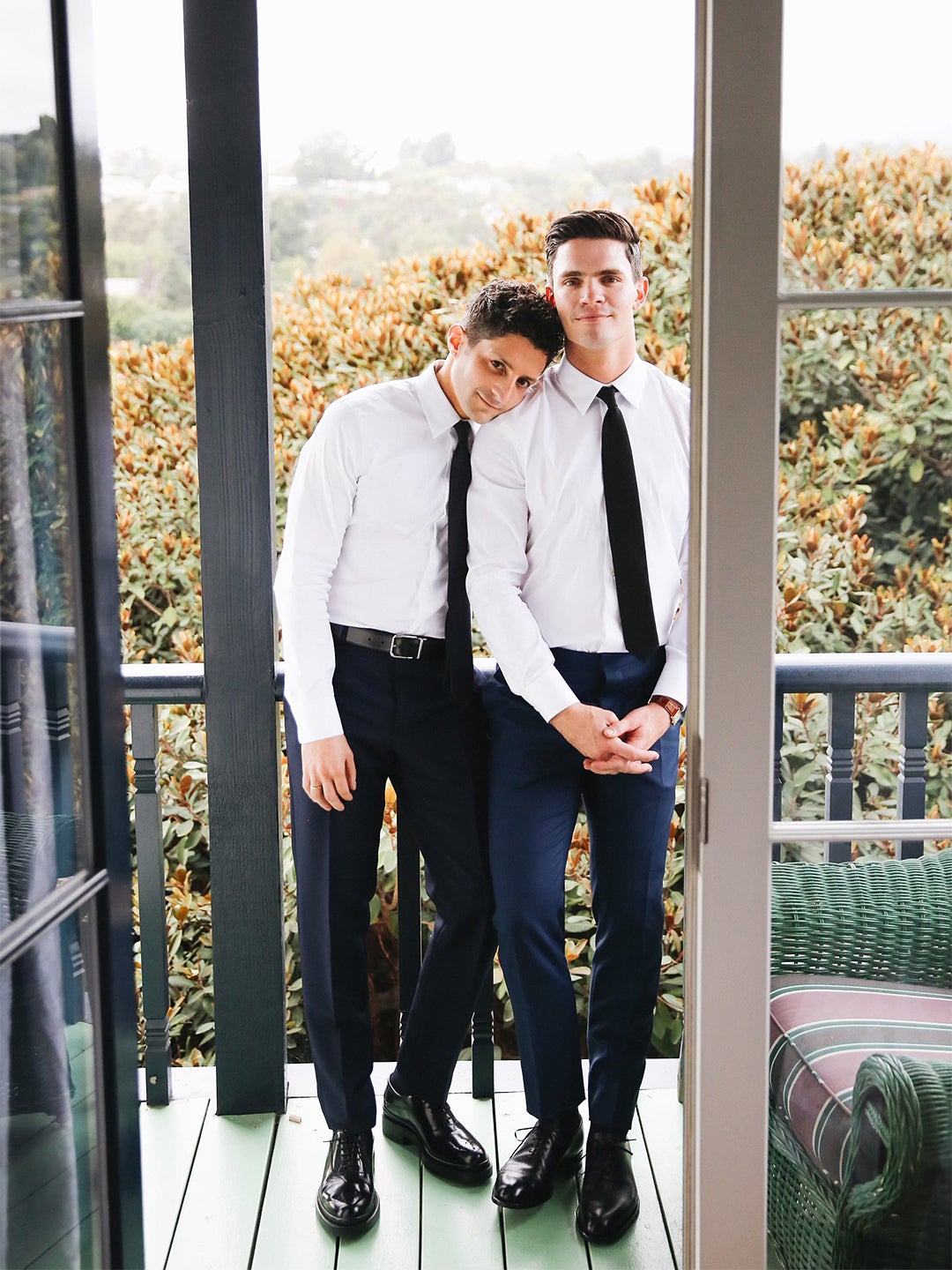 couple in suits on balcony at their wedding