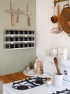 white spice rack on green kitchen wall