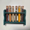 spices in test tubes in green wall rack