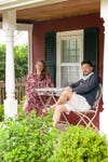 man and woman sitting outside house