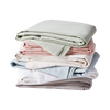 Stack of Percale sheets by Hawkins New York in pastel colorways