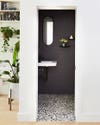 Black wall tiles, white sink and black mirror