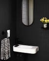 Black tiles, white sink and black mirror