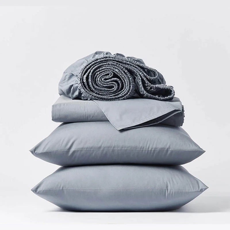 Blue Set of Sheets Rolled Up On Two Pillows
