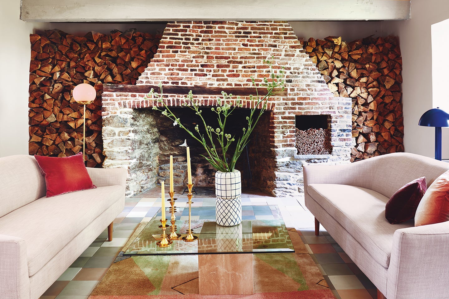 two cream sofas in front of old brick fireplace
