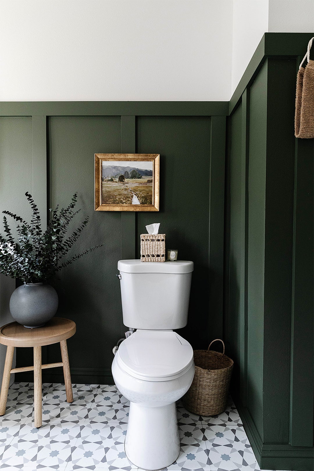 toilet with green wall panels behidn it