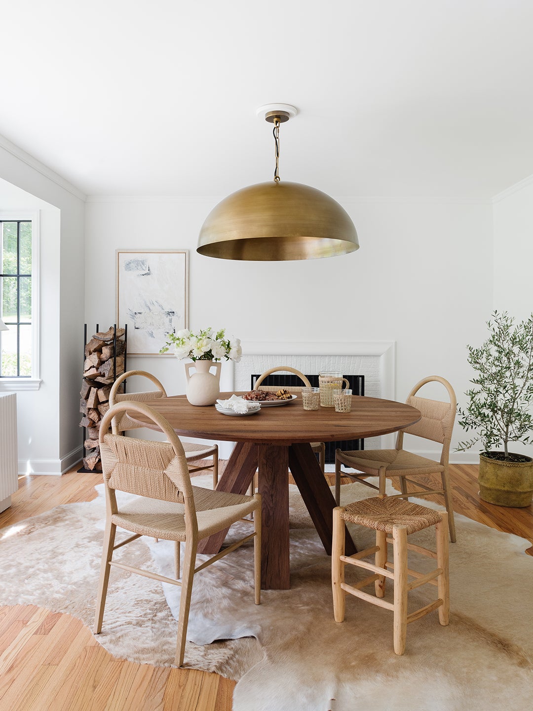 wooden dining table and chairs with brass chandelier