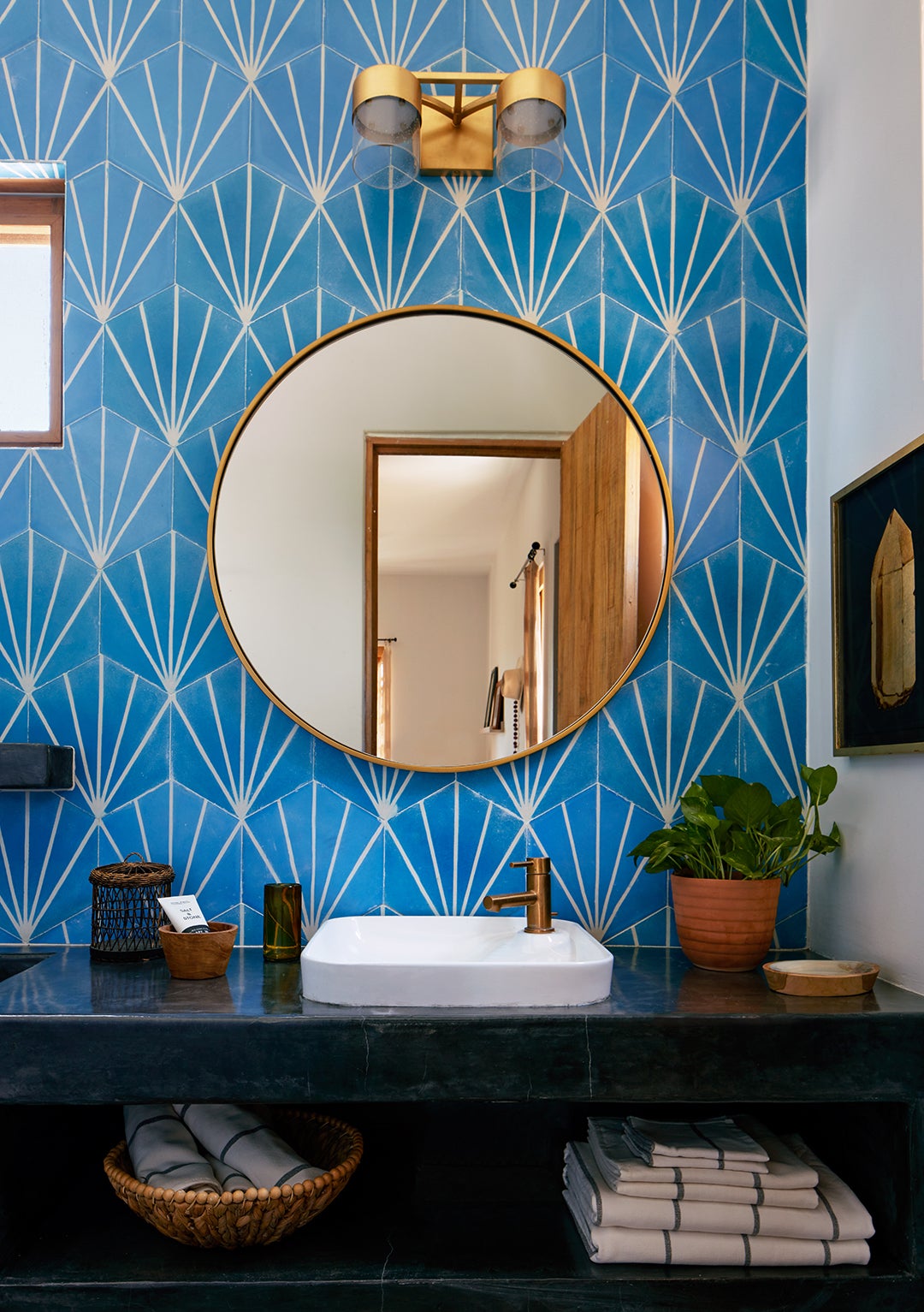 bathroom with round mirror and blue wall tile