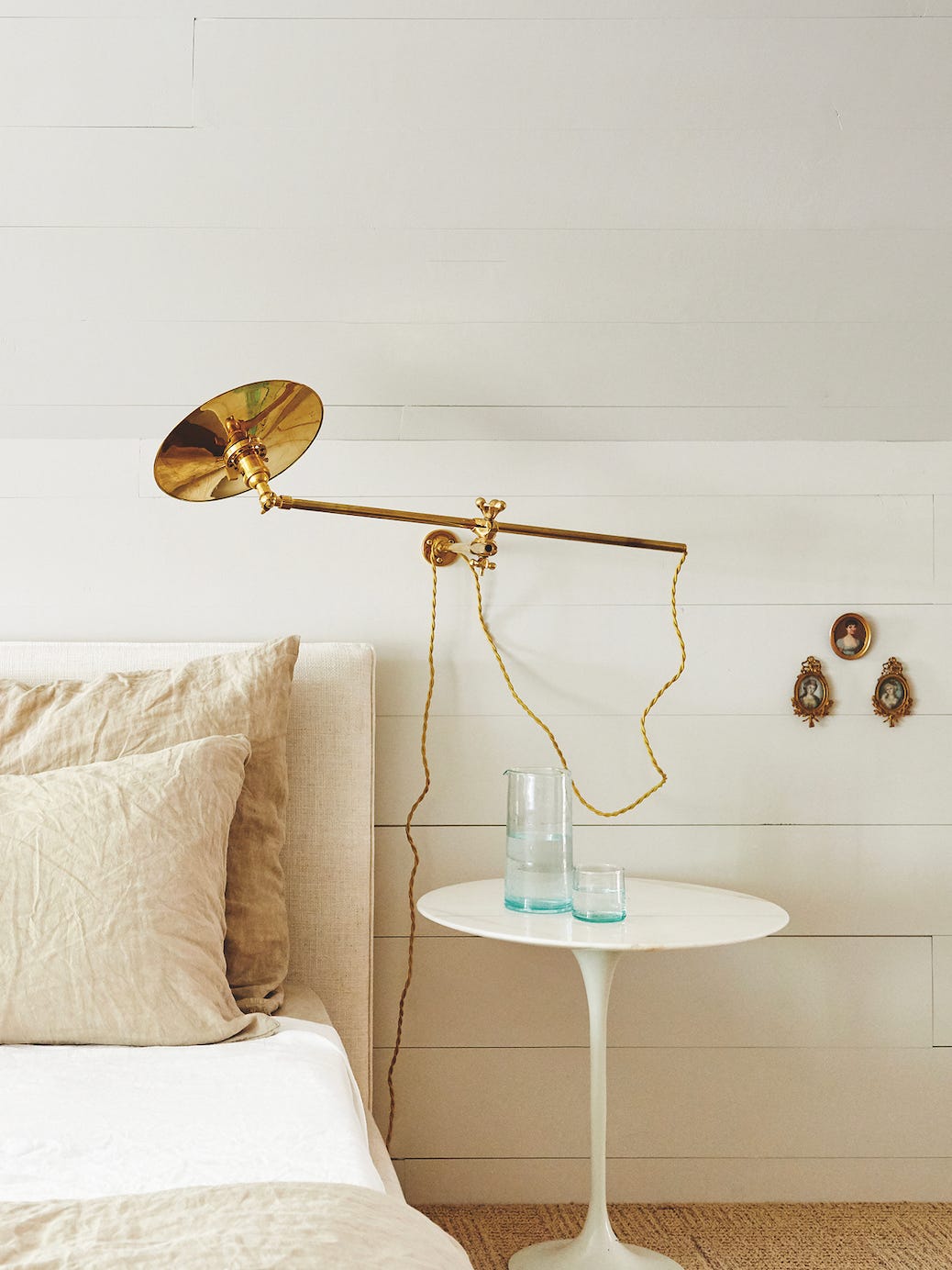 neutral bedroom with gold sconce