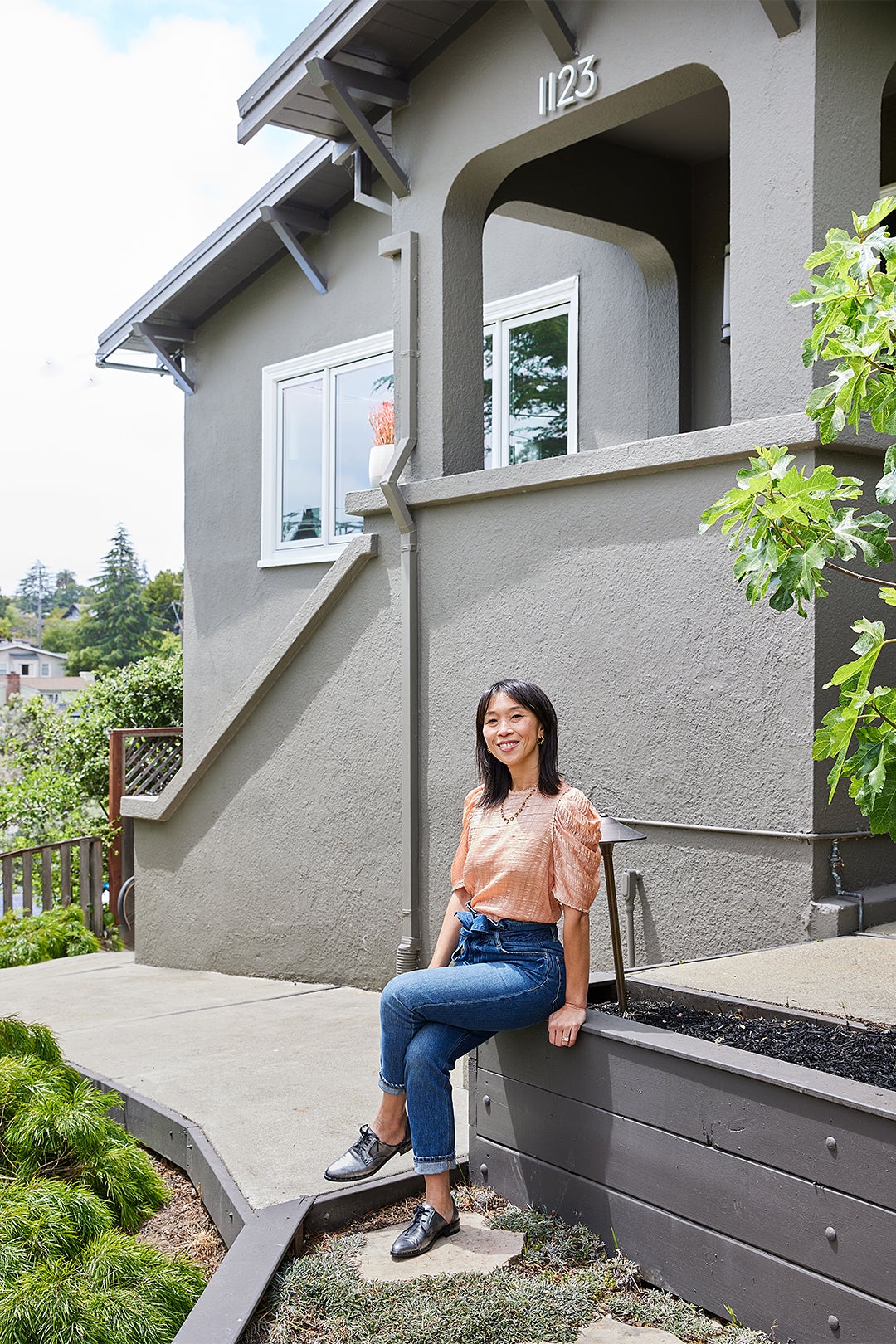 woman sitting in front go her house