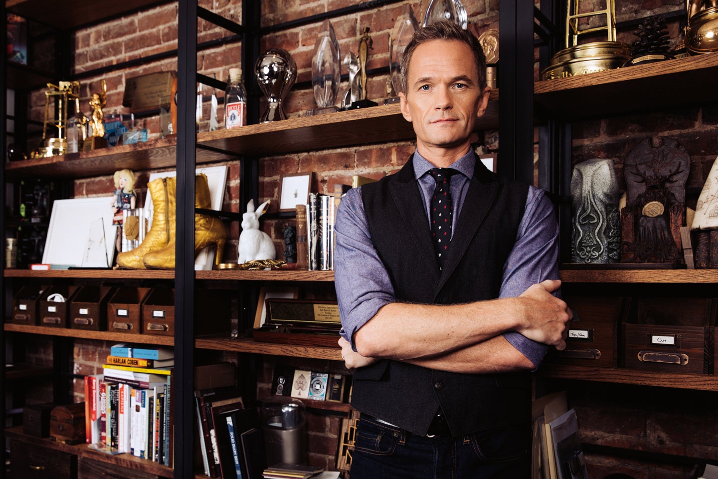 Neil Patrick Harris stands in front of bookcase