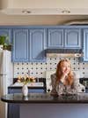portrait of girl in a kitchen with blue cabinets