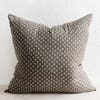 grey and brown pillow with dots