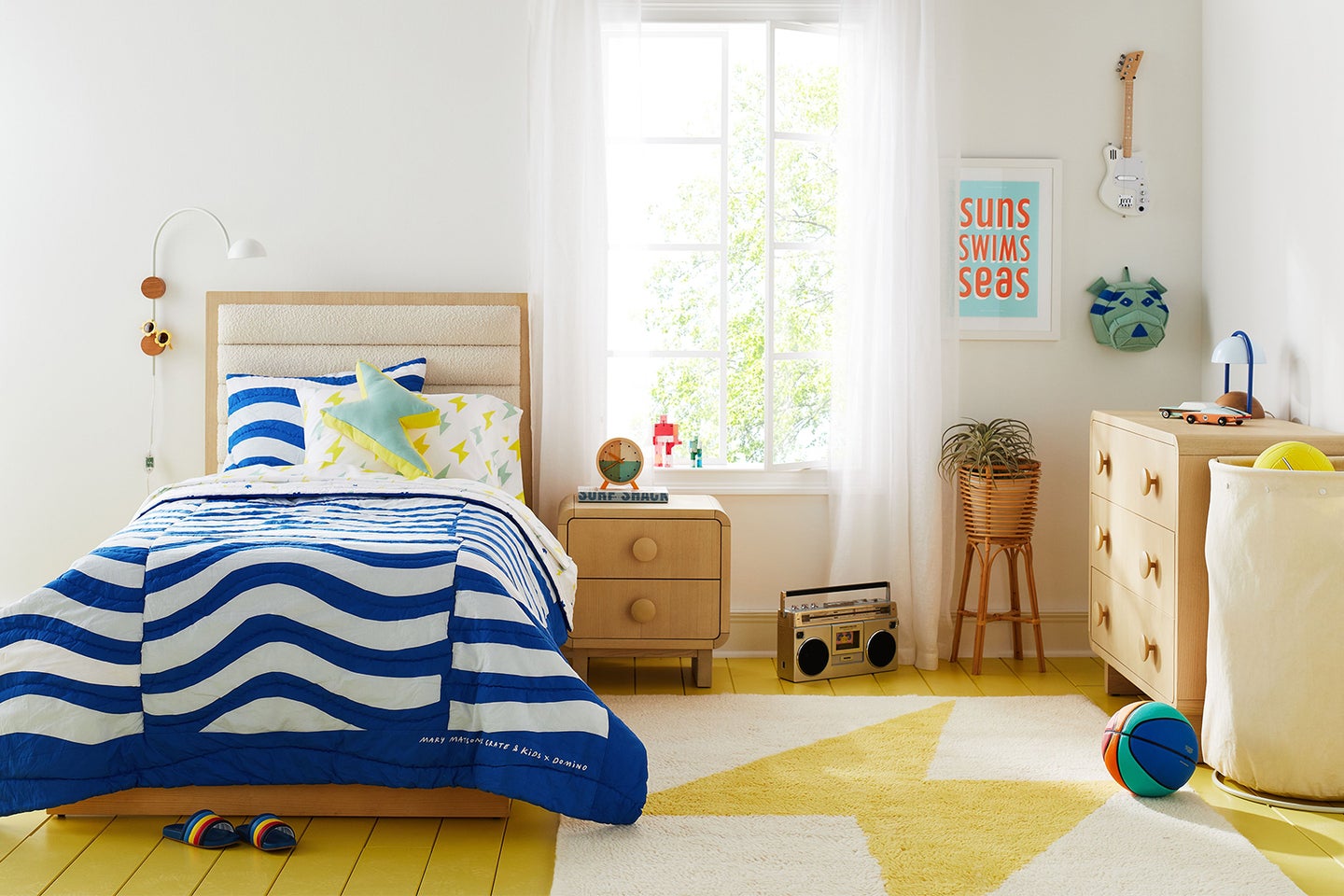 colorful kids bedroom with blue quilt and yellow rug