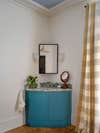 Soft Blue Ceiling with Blue Bathroom Corner Vanity and Gingham Curtains