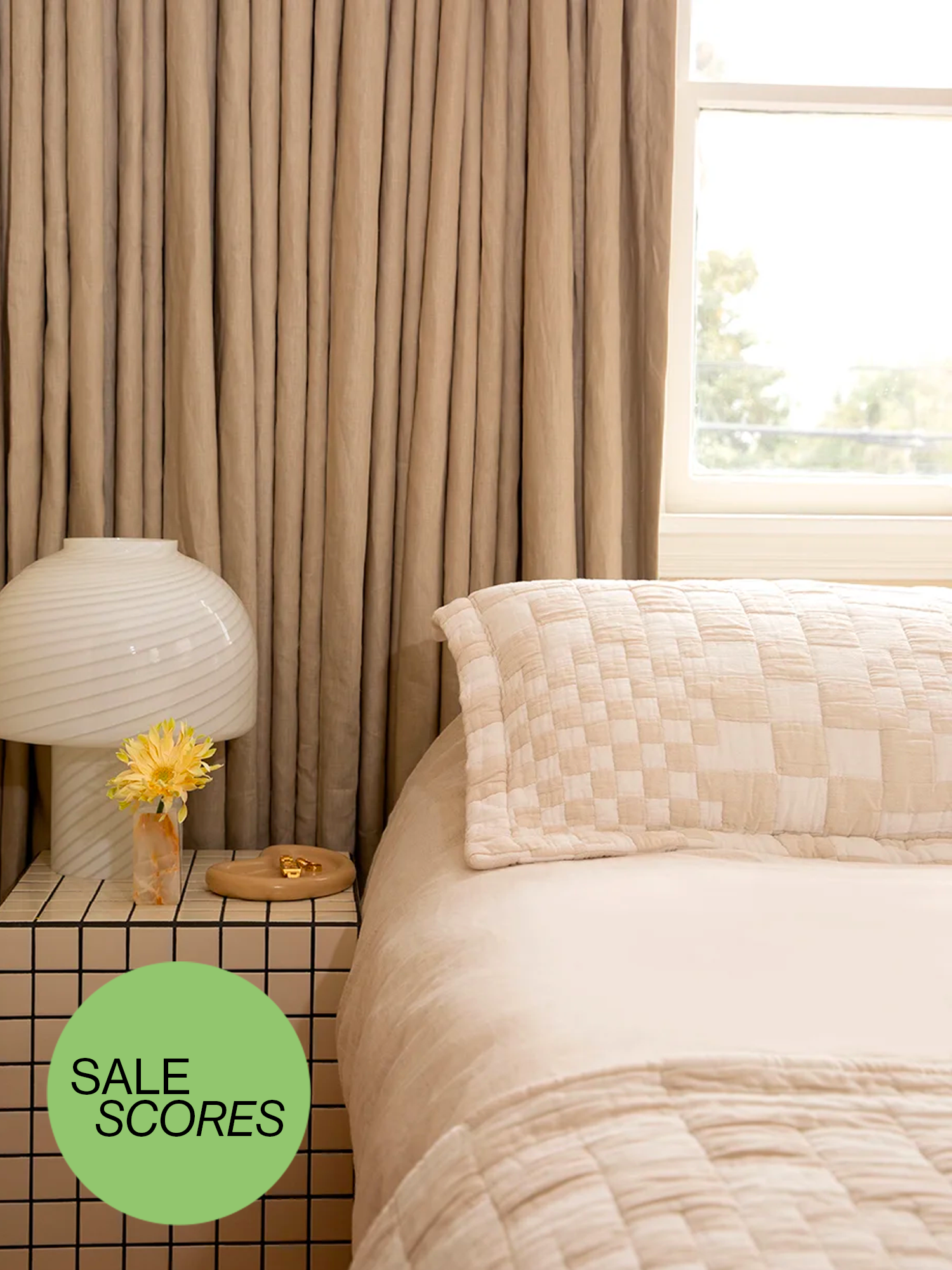 Neutral tone bedroom with checkered bedspread and side table.