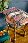 folded quilt on brass stool