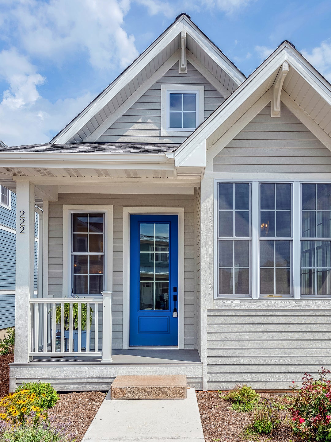 grey home exterior with blue door