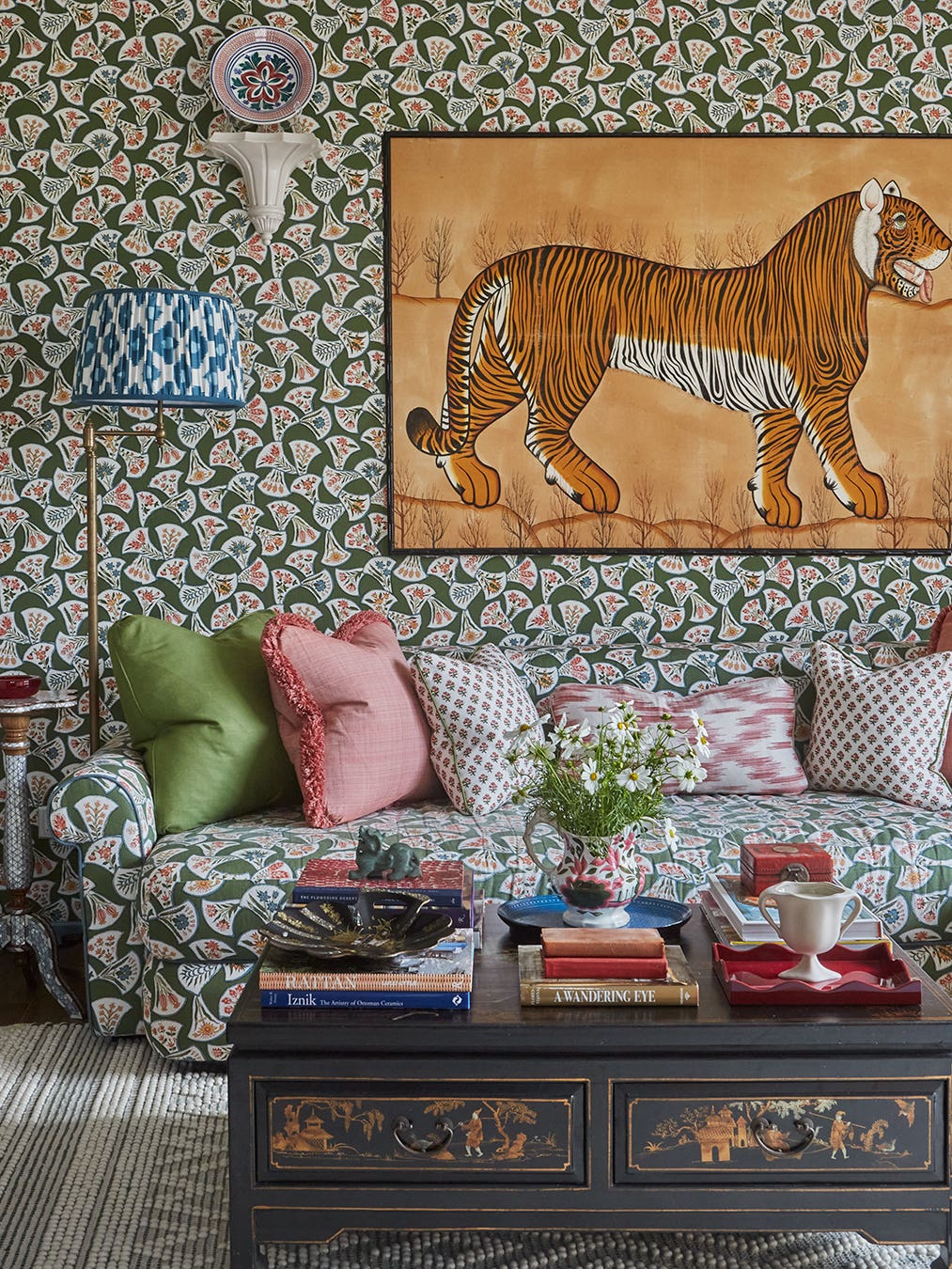 green patterned wallpaper and sofa with tiger artwork