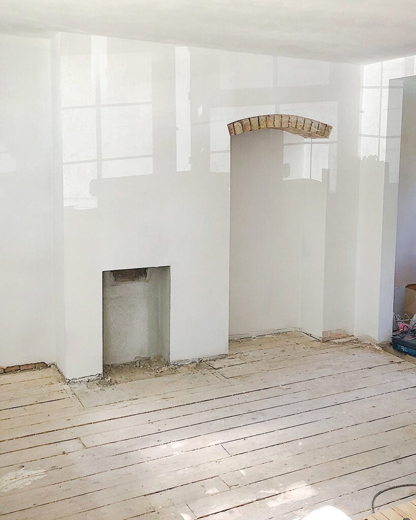 plastered room with exposed brick arch
