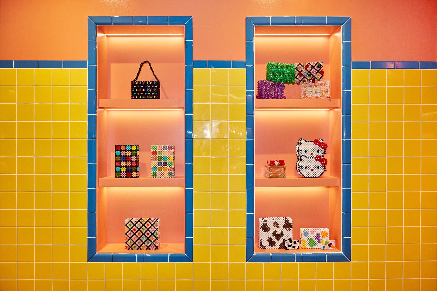 Design store interior with yellow tiles, orange shelves and walls and objects on shelves