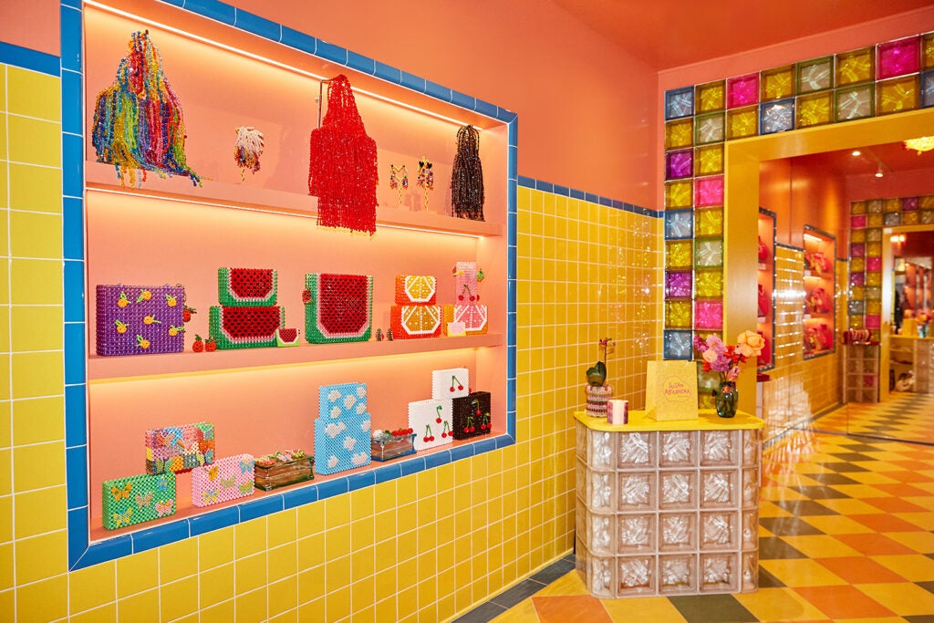 colorful store, yellow tiles on walks, orange painted ceiling, orange shelves with design objects exposed