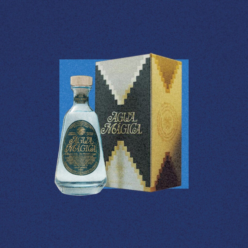 Glass Agua Magica mezcal bottle, midnight blue background