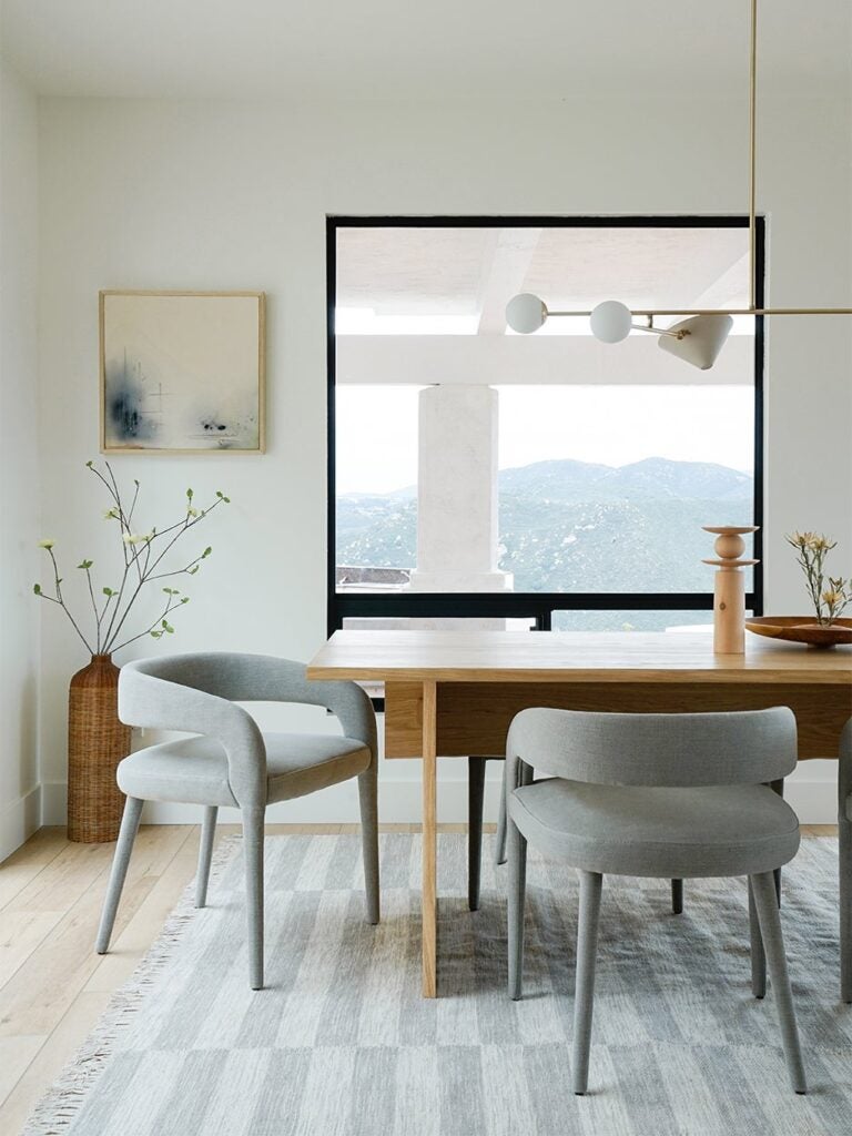 Gray dining chairs around wood table