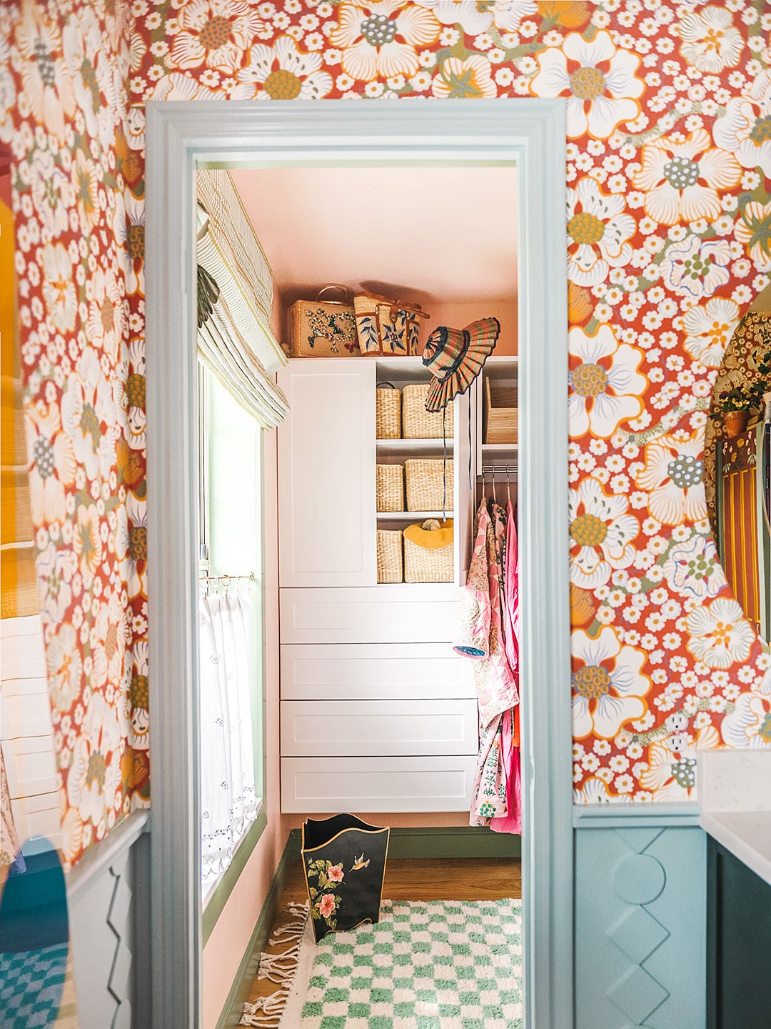 blue rectangular mirror, floral white and red wallpaper in a closet