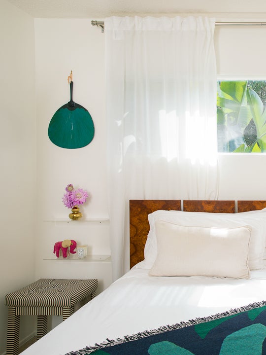 bedroom with green fan wall art