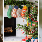 Schoolhouse stockings hung above fireplace next to Christmas tree